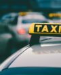 Selective focus shot of a yellow taxi sign in a traffic jam